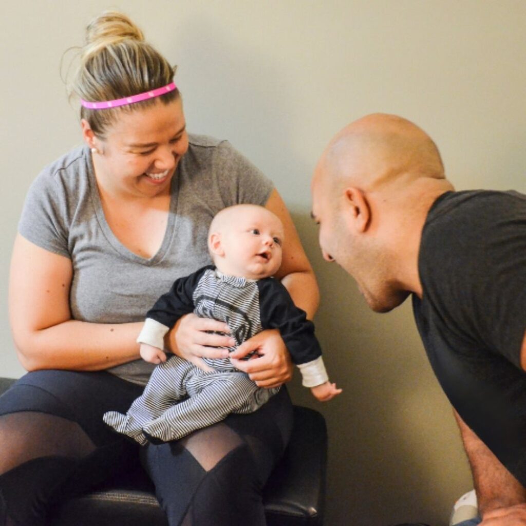 Chiropractor in Morristown TN Dr. Vic Manzo consulting with a mother and infant at The Wellness Path