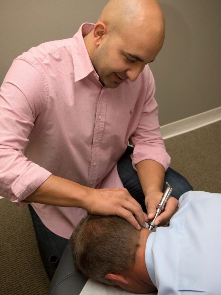 Dr. Vic Manzo performing a Torque Release Technique adjustment using the Integrator at The Wellness Path neuro-focused chiropractic clinic in Knoxville TN